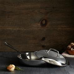 High-quality 18/10 stainless steel construction. Perfect for induction and other cooktops. Comes with a stay-cool handle for easy grip. Dishwasher-safe. Available in your choice of sizes. Oven- and broiler-safe. Handcrafted in the USA. Manufacturer provides limited lifetime warranty. Your recipes needn't be French for the All-Clad Tri-Ply Stainless Steel French Skillet with Lid to make its mark on your kitchen. Its lovely design will increase your cooking acumen all the same, whether your favorite dishes are Mediterranean, European, or American classics. This easy-to-use skillet is designed for searing, browning, and pan frying, with a premium tri-ply stainless steel construction and interior aluminum core that together provide even heating and exceptional performance. The skillet has round, sloped sides that prevent splattering and allow for easy tossing and turning of food with a spatula. The starburst interior finishing offers excellent stick resistance, and the domed lid keeps everything under control. This skillet is dishwasher, broiler, and freezer-safe, and usable on induction and standard cooktops. About All-CladFounded in 1971 in Canonsburg, Pennsylvania, All-Clad Metalcrafters produces the world's finest cookware in its Southwestern Pennsylvania rolling mill, using the same revolutionary processes that they introduced forty years ago. Today, All-Clad is the only bonded cookware that's handcrafted by American craftsmen using American-made metals. Originally founded to meet the highest standards of professional chefs, All-Clad has become the premier choice of cookware enthusiasts of all experience levels, from world-class chefs to passionate home cooks in everyday American kitchens. The unsurpassed quality and performance of All-Clad cookware is derived from its innovative roll bonding process, which uses a proprietary recipe of metals. Cladding is applied not just to the bottom, but also up the sides of each All-Clad cooking vessel, providing outstanding heat distribution and reliable cooking results. All-Clad cookware is hand-inspected at every stage of the manufacturing process and is famous for the uncompromising quality that's evident in every detail, from its impeccable balance in your hand to its meticulous hand-finishing. Size: 9 in.